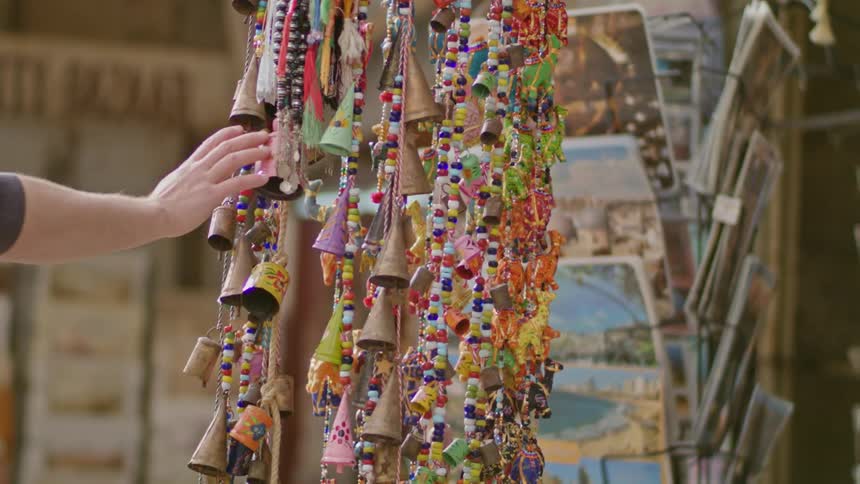 Chains of bells hang and are touched by a person