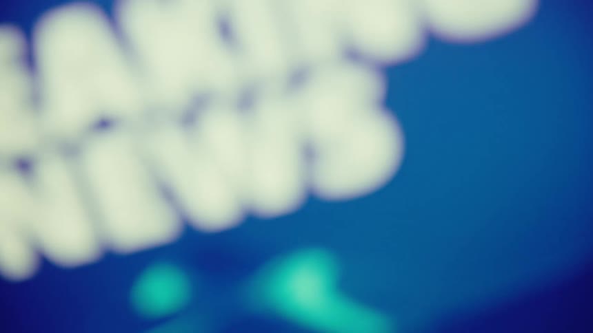 Screen displays breaking news in bold white text on a blue background