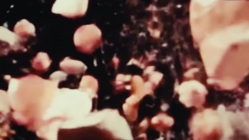 A piggy bank shatters into pieces that fall into a black background