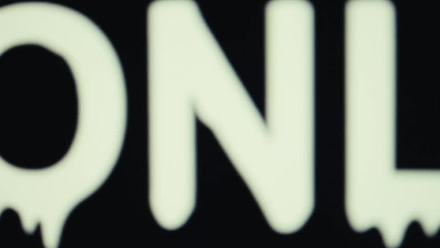 A vintage digital video shows the word online in a white dripping font on a black background with a glitchy effect that changes it to offline