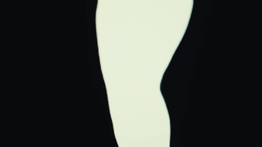 A silhouette of a dancing woman moves upwards on a black background
