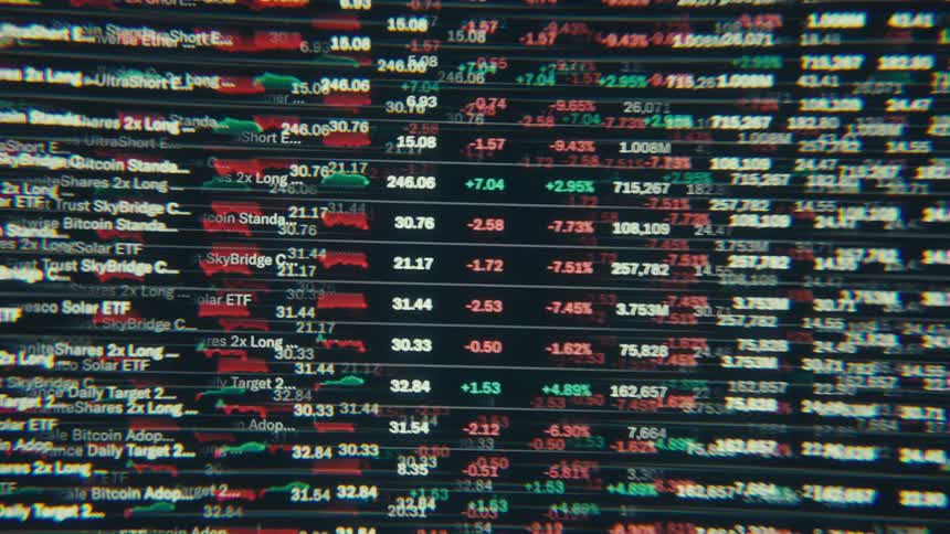 A digital screen shows rows of fluctuating stock market data