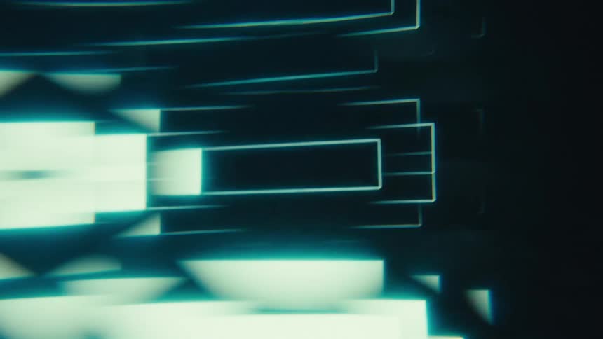Closeup of a screen with glowing geometric light patterns against a dark background