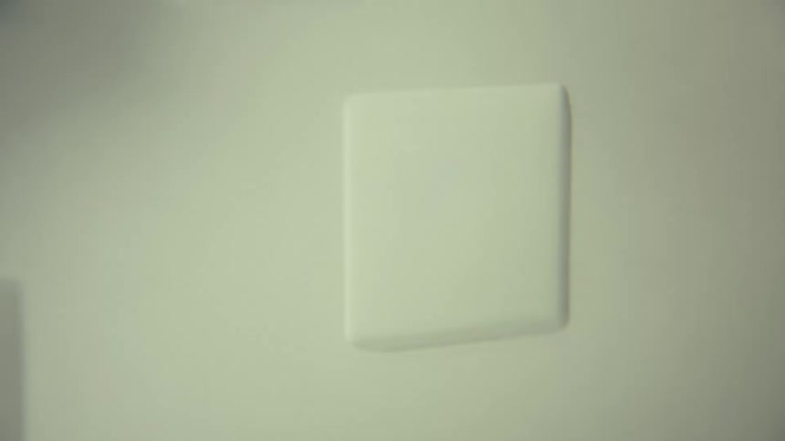 A shot shows an abstract background with shapes of clouds and squares moving on a screen