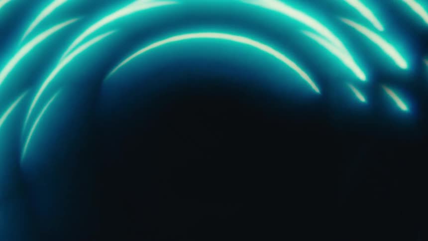 An abstract animation shows several curved lines of neon blue light rotating in a circular pattern against a dark background the camera moves closer to the center of the ring causing the lights to blur and fill the entire screen with a bright swirling