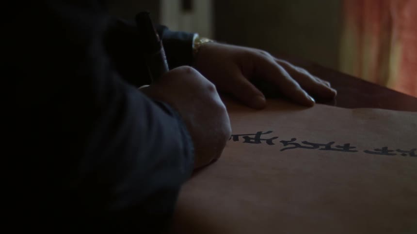A man uses a marker to write on a piece of paper