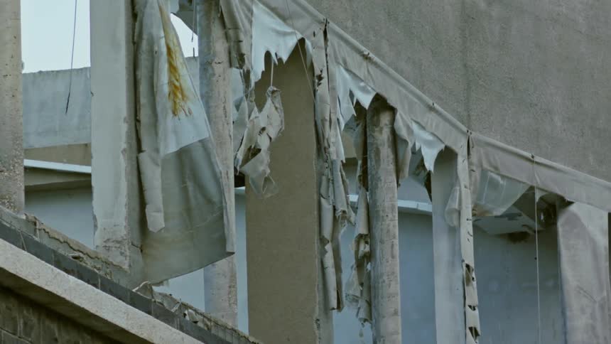 Torn material hanging from pillars of old building