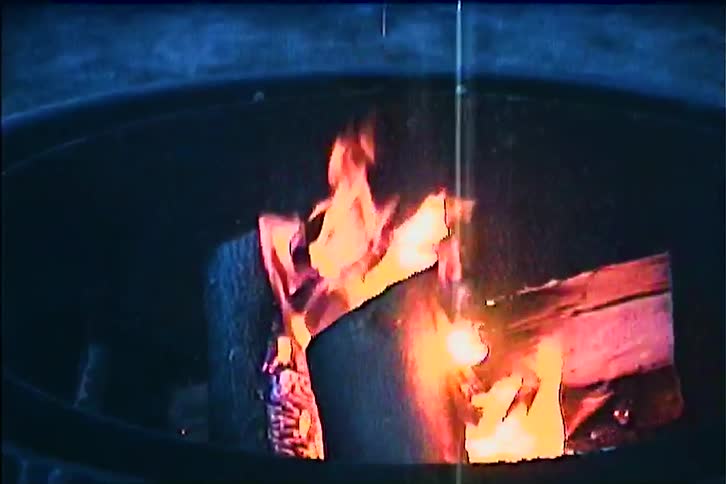Bonfire burning inside a metal container outdoors