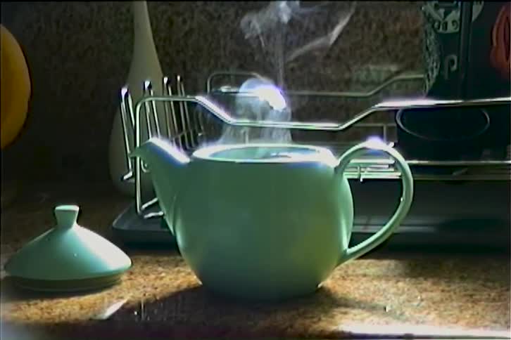 Close up of an open kettle on a kitchen counter containing hot liquid