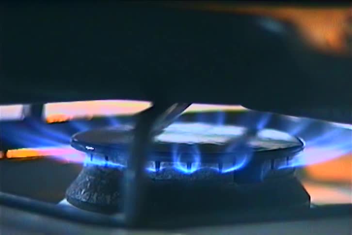 Closeup of a blue gas flame on a stove burner