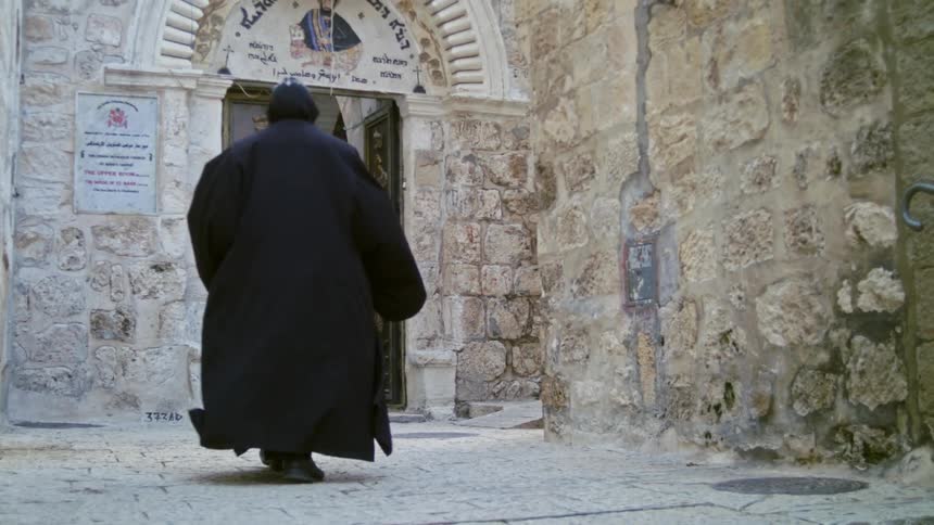 A man in robes walks into a church