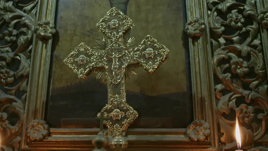 Candles burn near a crucifix