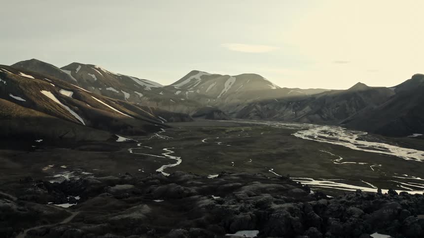 Snow is melting off the mountains and the water runs down into the river