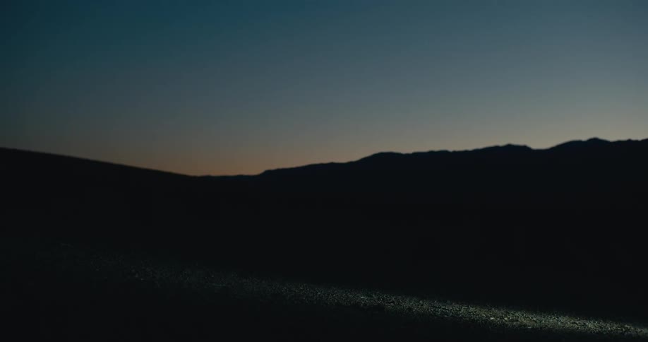 Cyclist cycling at night through the countryside gets off his bike
