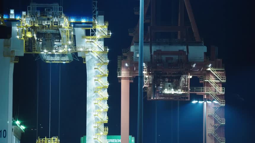 Well lit building structures at a shipping terminal at night