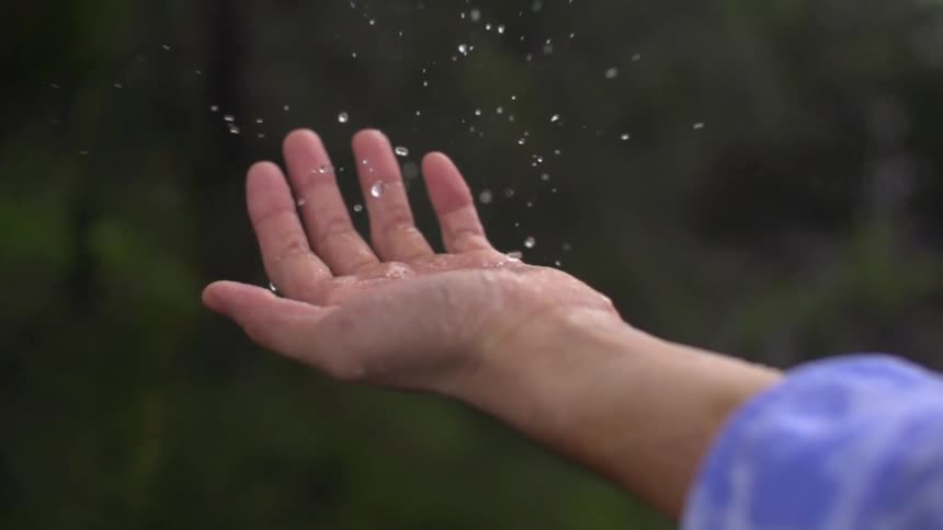 Water drips around and onto a person's hand