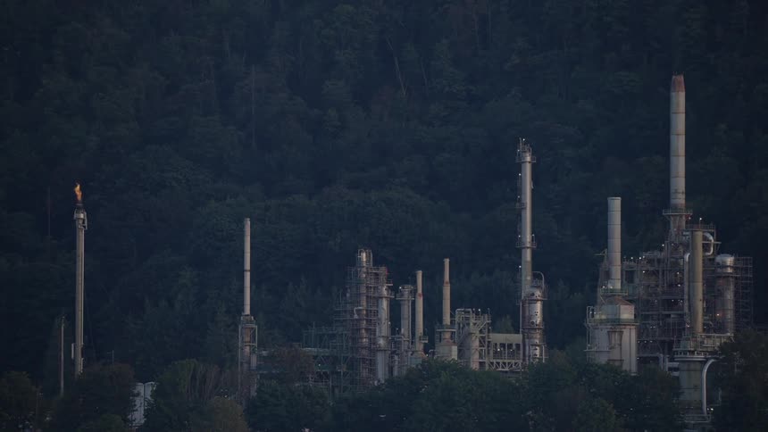 A refinery building with various metal structures during daytime