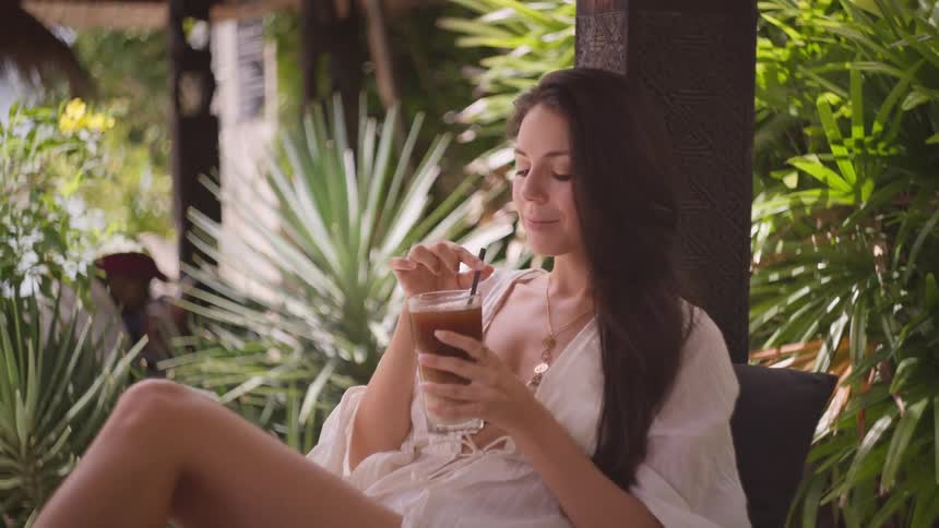 The woman is relaxing and drinking at the resort