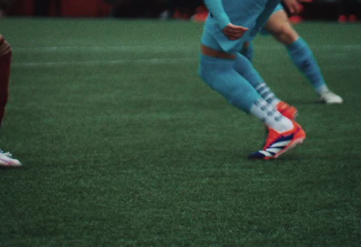 A soccer player going through the field with the ball dodging other players until he kicks the ball forward