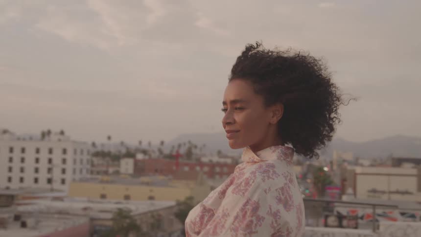 The woman looks over the city from the rooftop