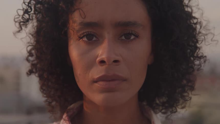 Closeup of a woman looking calmly into the camera at sunset