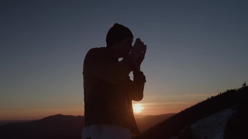 The man aims his camera to take a picture