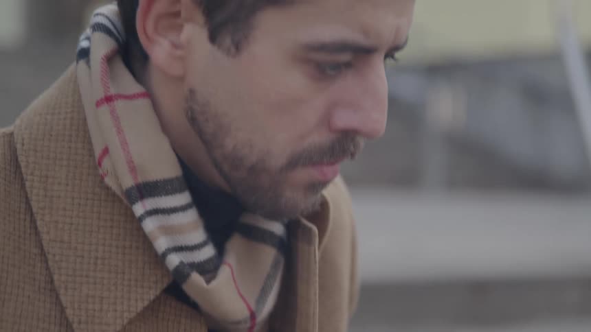 The man is sitting on the steps and typing on his computer