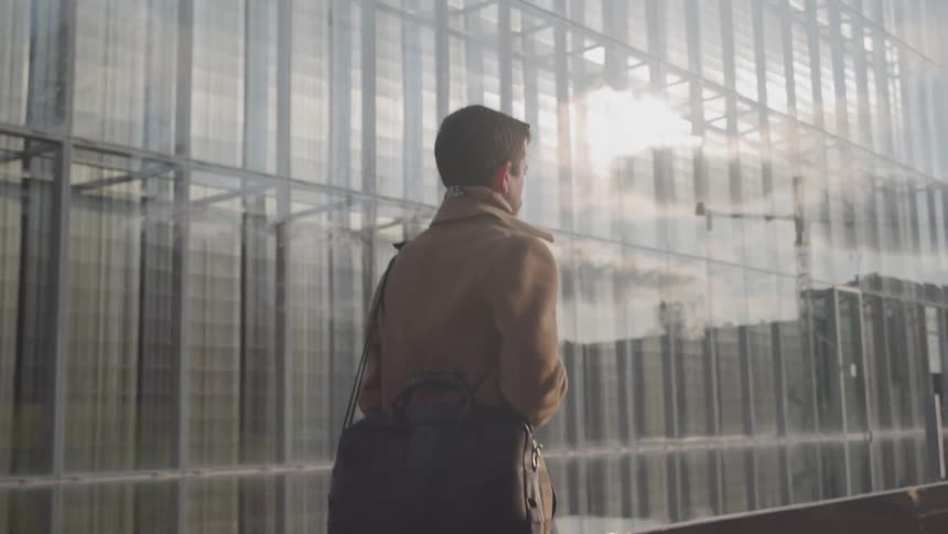 The man walks past the building in the city