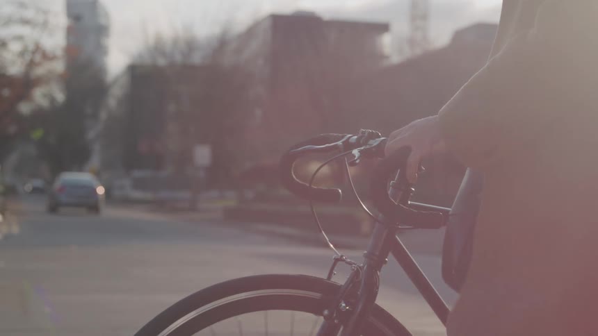 Person pushing a bicycle on an urban street