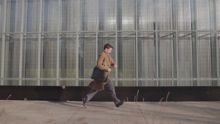 The man runs by the building
