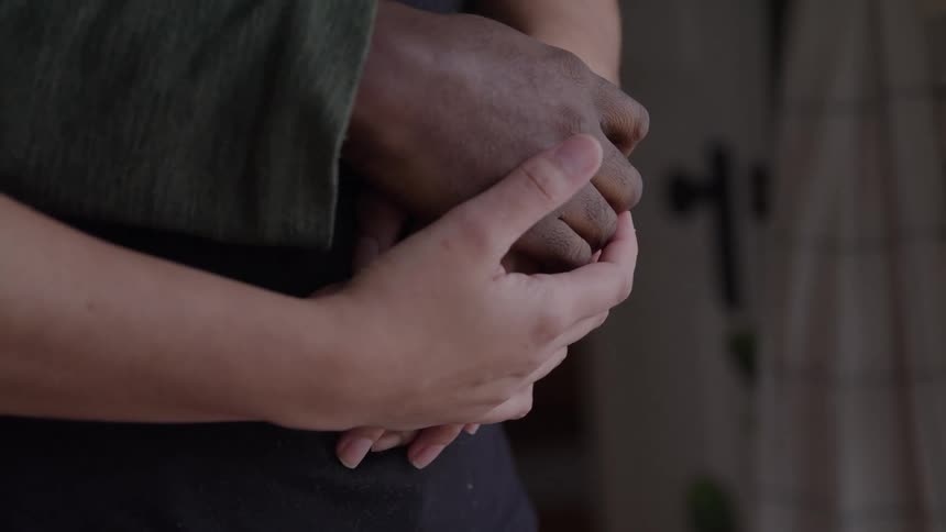 Two people holding hands in a gesture of affection