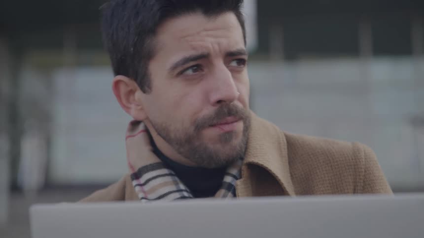 The man looks at his laptop and nods