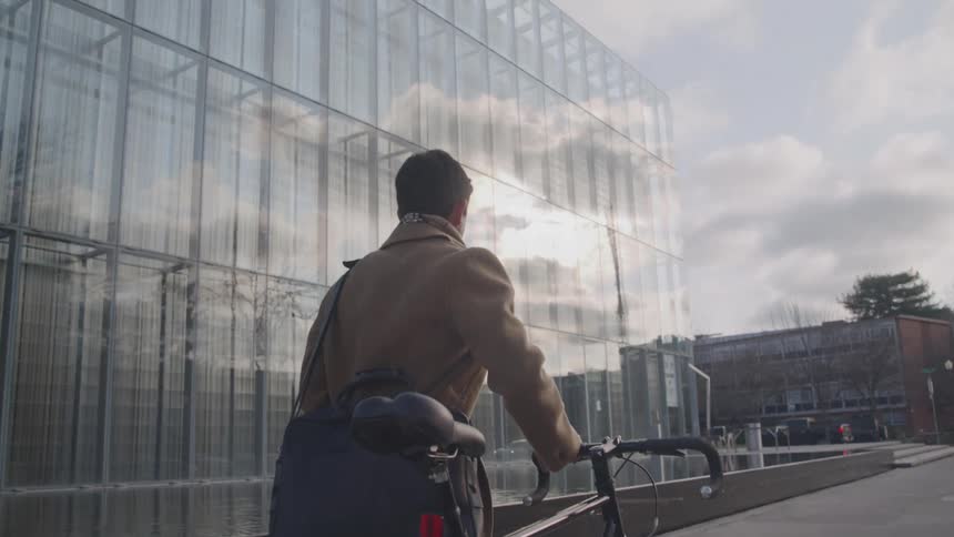 Man walking with his bicycle through the city