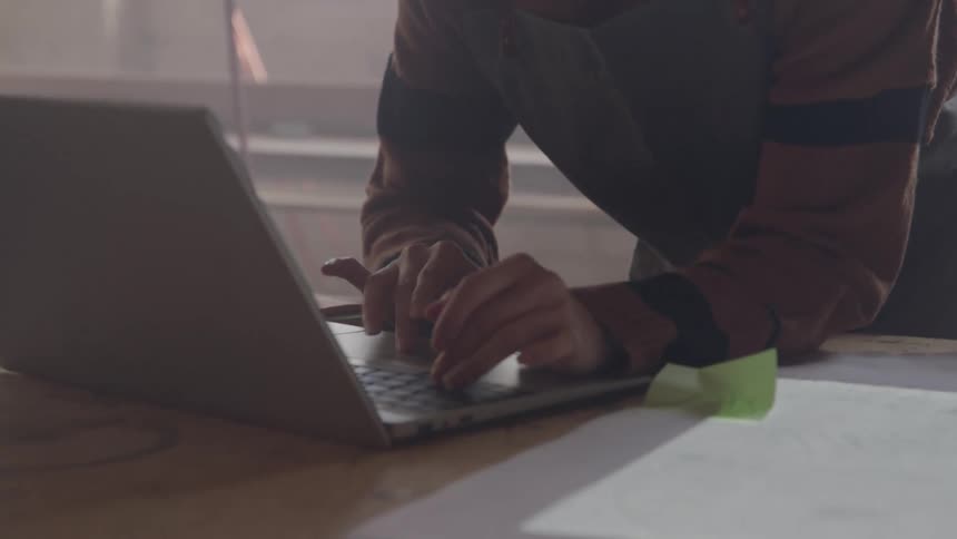 Woman in apron interacting with a laptop