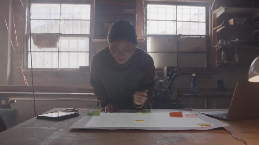 Woman writing on colorful papers on the work table