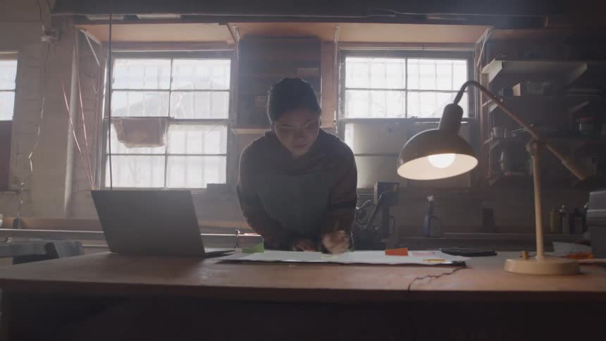The woman is writing on a large piece of paper
