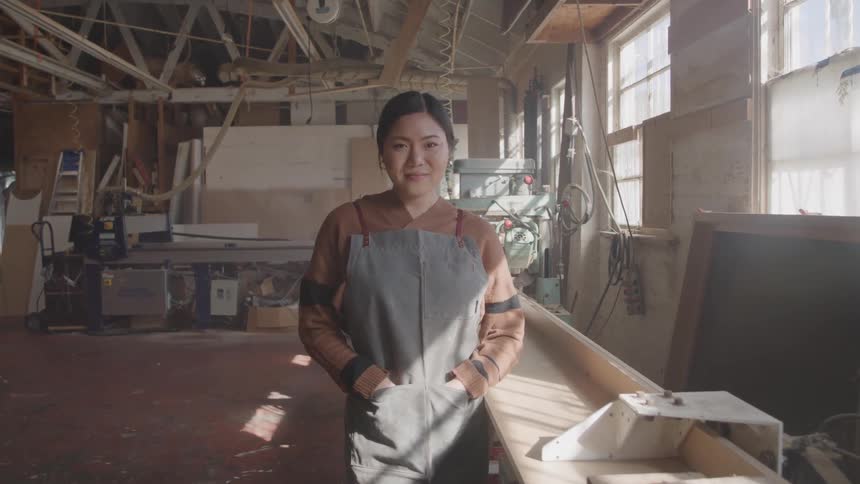 The woman is smiling in the workshop