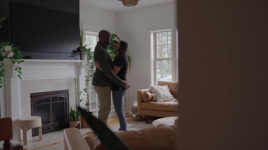 A man and woman dance together in the living room