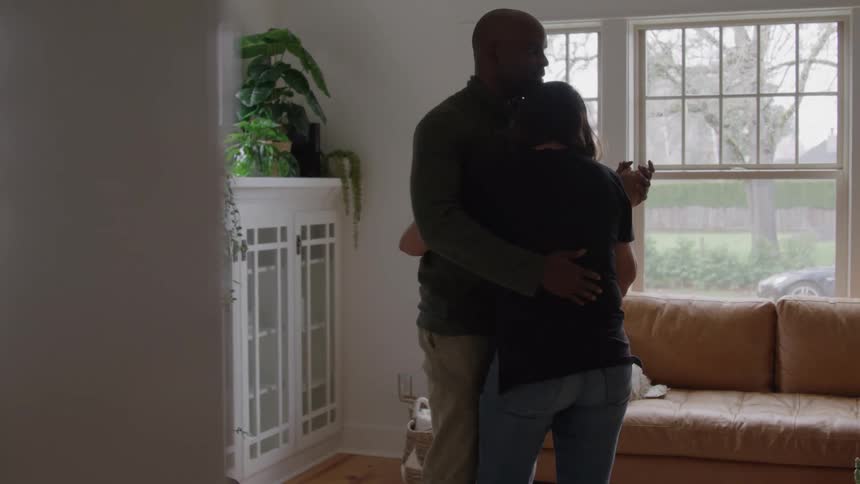 The couple are slow dancing at home