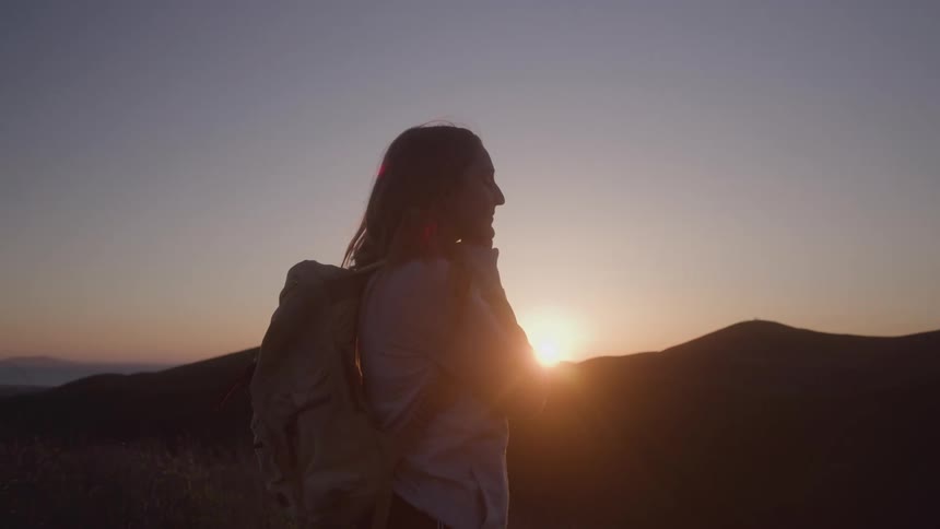 Woman on a mountain in the late afternoon with a happy expression