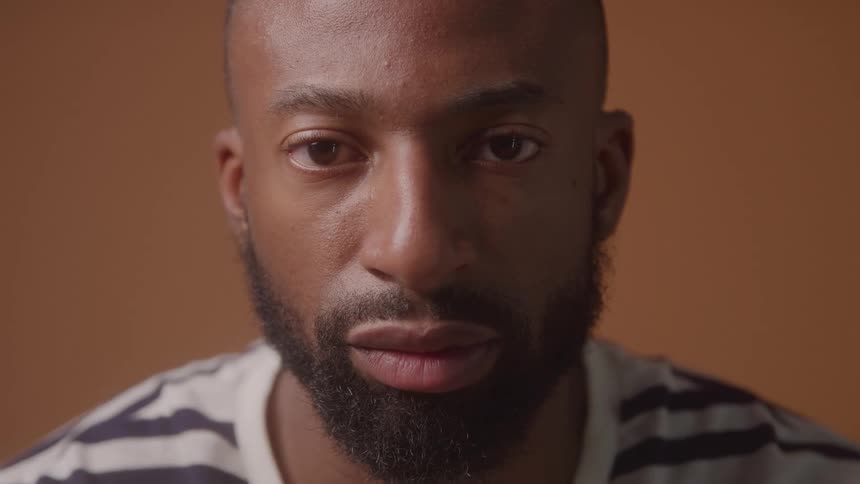 A mans face is shown as he looks to his left and then looks into the camera