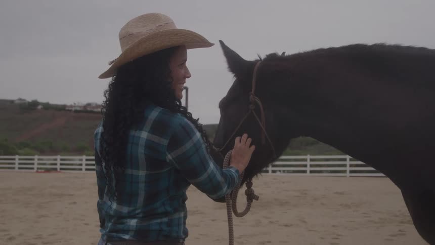 A woman pets her horse