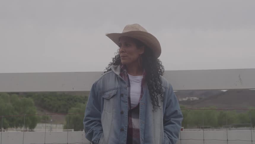 A woman standing and wearing a hat
