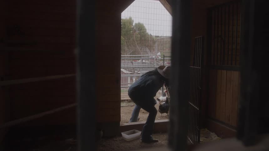 A woman steps out of a doorway bends over and stands up again