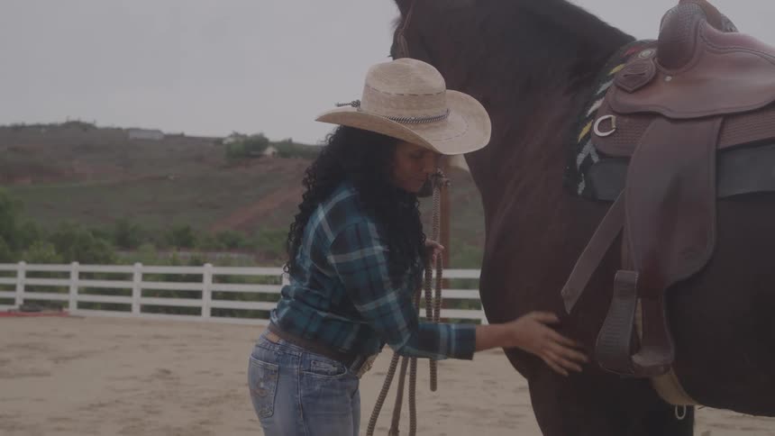 A woman pets her horse