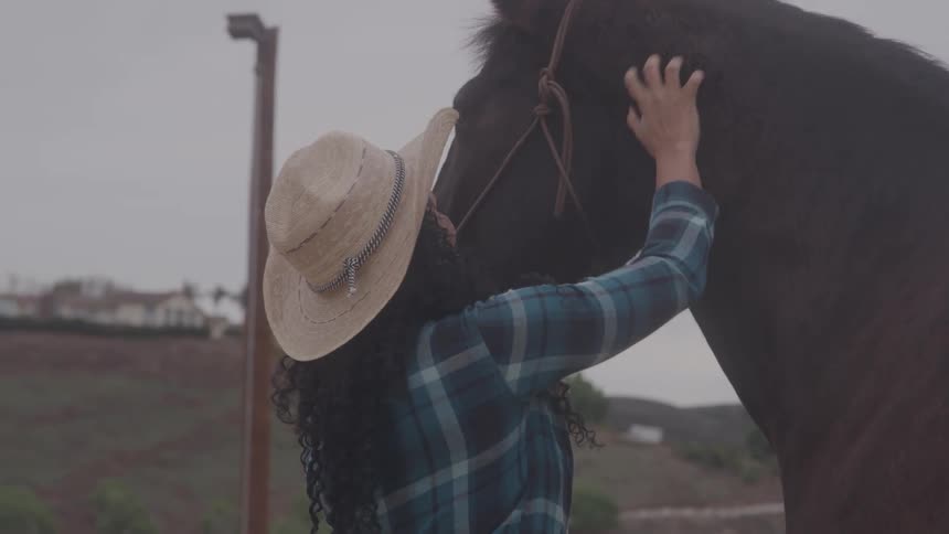A woman pets her horse