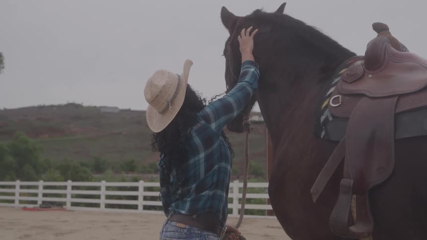 A woman pets her horse