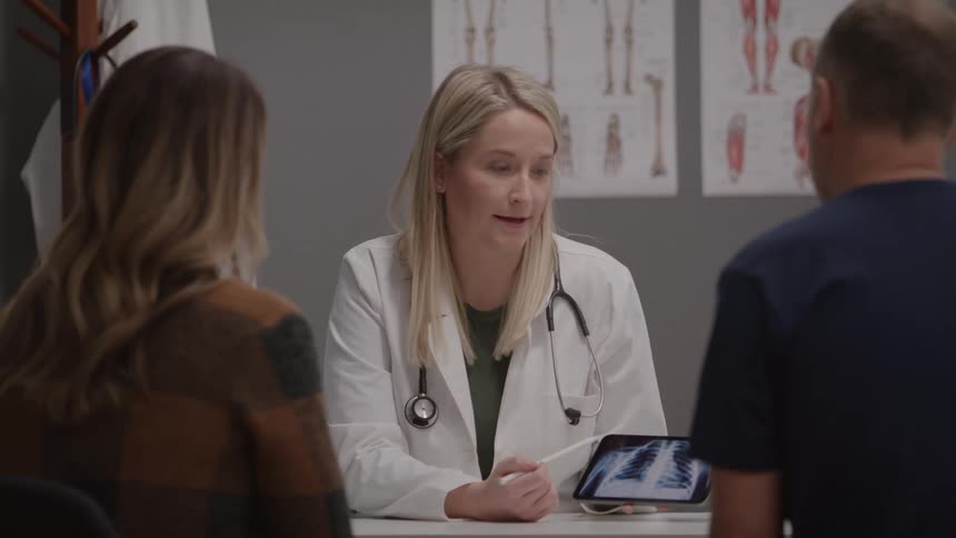 Doctor shows an xray exam to two patients during the consultation