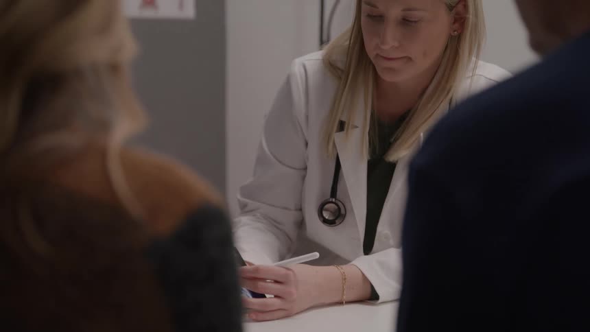 The doctor is talking with patients and showing them an x ray