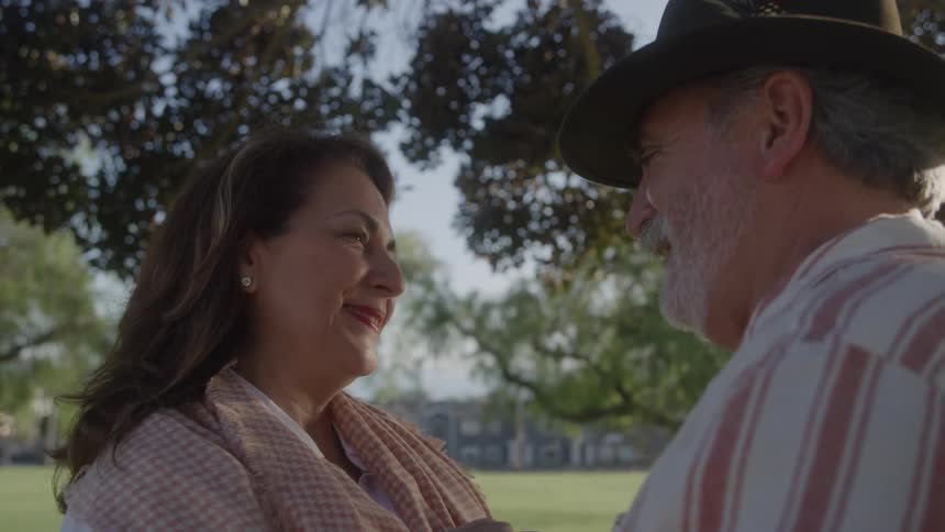 Couple smiling at each other in a treefilled park